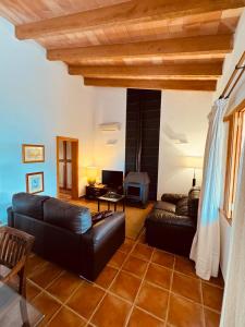 a living room with a leather couch and a fireplace at Finca Ses Barraques in Manacor