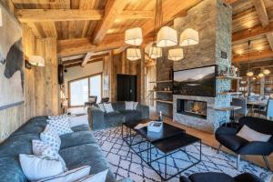 een woonkamer met een bank en een open haard bij Résidence Bois De L'abbaye - Chalets pour 12 Personnes 484 in le Praz