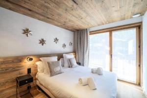 1 dormitorio con cama blanca y ventana grande en Résidence Bois De L'abbaye - Chalets pour 12 Personnes 484 en Le Pra