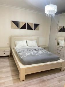 a bedroom with a bed and a chandelier at אלמוג על הים in Haifa