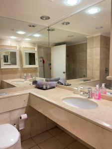 a bathroom with two sinks and a large mirror at אלמוג על הים in Haifa