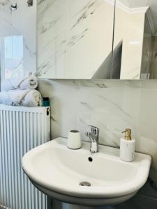 a bathroom with a white sink and a mirror at Thomais Guesthouse in Kavala