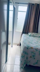 ein Schlafzimmer mit einem Himmelbett und einem Fenster in der Unterkunft Apartamento mobiliado em Aracaju in Aracaju