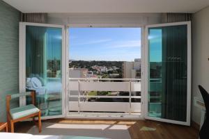 a room with a balcony with a view of the city at Vilamoura Sunrise in Quarteira