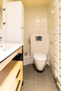 La salle de bains blanche est pourvue de toilettes et d'un lavabo. dans l'établissement Spacious flat 120m2 close to Eiffel Tower, à Paris