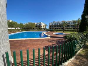 uma piscina com uma cerca ao lado de um edifício em Piso de lujo - descansar y trabajar en Golf Panoramica para 4 pers - internet fibra GRATIS em Sant Jordi