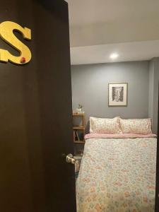 a bedroom with a bed and a letter s on the wall at Exclusivas Habitaciones al Oriente in Mexico City