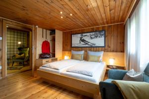 a bedroom with a large bed with a wooden ceiling at Chalet Kasern in Gais