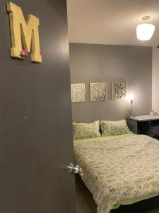 a bedroom with a bed with a letter m on the wall at Exclusivas Habitaciones al Oriente in Mexico City +14 photos