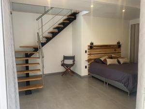1 dormitorio con 1 cama y escalera de caracol en chez Yannick, en Salento
