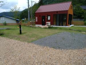 a small red building with a red roof at Ayu no Sato Park Campsite - Vacation STAY 42240v in Shōbara