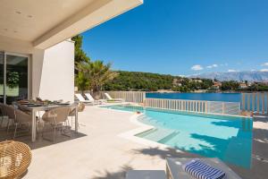 a patio with a table and a swimming pool at Villa More in Selca