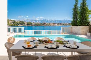 a table with food on it next to a swimming pool at Villa More in Selca