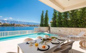 a patio with a table and chairs and a swimming pool at Villa More in Selca
