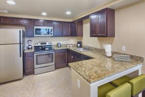 a kitchen with wooden cabinets and a white refrigerator at Holiday Homes 1 Room 2 Bed 1 Bathroom 4 Occupants in Orlando