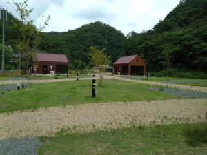 um campo verde com dois edifícios e um edifício em Ayu no Sato Park Campsite - Vacation STAY 42240v em Shōbara