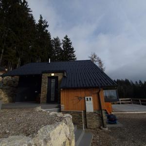 Cabaña de madera pequeña con techo negro en Koča z razgledom, en Križe