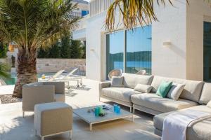 a living room with couches and a palm tree at Villa More in Selca