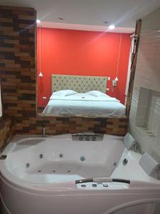 a bath tub in a room with a bed at HOTEL EL CACIQUE POPAYAN in Popayan