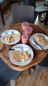 una mesa de madera con platos de comida. en The Chill in Mansion Hostel Santa Marta en Santa Marta