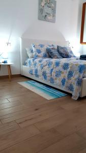 a bedroom with a bed with a blue and white comforter at VillaVittoria in Chia