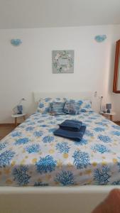 a bed with a blue and white comforter on it at VillaVittoria in Chia