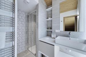 uma casa de banho com um lavatório branco e um espelho. em Résidence Les Alpages - 5 Pièces pour 8 Personnes 714 em La Rosière