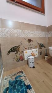 a bathroom with a turtle mural on the wall at VillaVittoria in Chia