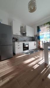 a kitchen with white appliances and a wooden floor at VillaVittoria in Chia