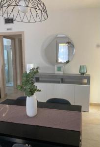 Zimmer mit einem Tisch, einem Spiegel und einer Vase in der Unterkunft LULIWA in Santarcangelo di Romagna