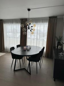 a dining room table with chairs and a chandelier at Hus med 2 soverom in Sortland