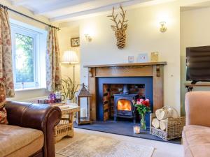 a living room with a fireplace and a tv at 4 Bed in Symonds Yat 79373 in Goodrich