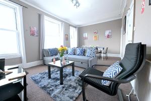 ein Wohnzimmer mit einem Sofa und einem Tisch in der Unterkunft STUNNING 3 Bedroom Serviced Flat IN North London in London