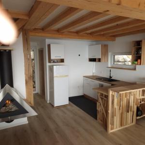 een keuken en een woonkamer met een open haard bij Koča z razgledom in Križe