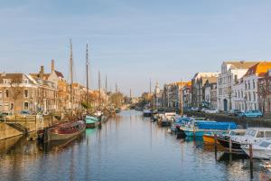 eine Gruppe von Booten, die in einem Kanal mit Gebäuden angedockt sind in der Unterkunft Sonder Rose in Rotterdam