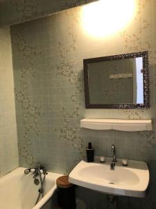 a bathroom with a sink and a mirror and a tub at Résidence Les Glovettes - Studio pour 4 Personnes 404 in Villard-de-Lans