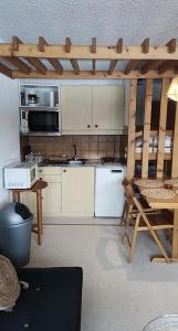 a kitchen with white appliances and a table and a tableablish at Résidence Les Glovettes - Studio pour 4 Personnes 404 in Villard-de-Lans