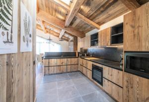 a large kitchen with wooden walls and wooden counters at Résidence Bois Du Fontanil - Chalets pour 12 Personnes 474 in le Praz