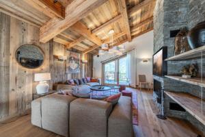 a living room with a couch and a fireplace at Résidence Bois Du Fontanil - Chalets pour 12 Personnes 474 in le Praz