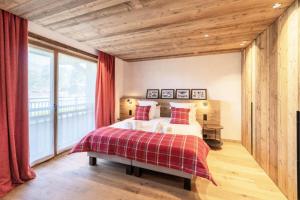 a bedroom with a bed and a large window at Résidence Bois Du Fontanil - Chalets pour 12 Personnes 474 in le Praz