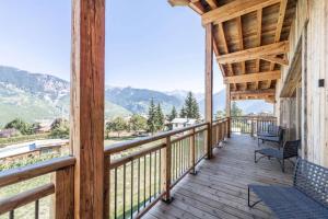 a wooden porch with chairs and a view of mountains at Résidence Bois Du Fontanil - Chalets pour 12 Personnes 474 in le Praz