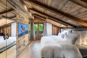 een slaapkamer met een groot wit bed en houten plafonds bij Résidence Casa Martinha D'arbois - Chalets pour 8 Personnes 004 in Megève