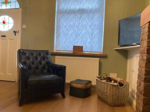 a living room with a chair and a television at Adlington Cottage, Lancashire in Adlington
