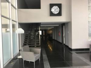 een lobby met een stoel en een trap in een gebouw bij Lujosa Suite; confort, seguridad in Guayaquil