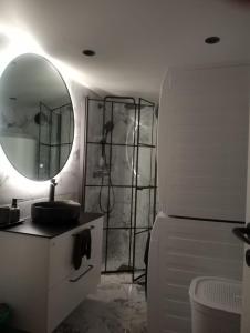 a bathroom with a mirror and a sink and a refrigerator at Slattum terrasse in Skytta