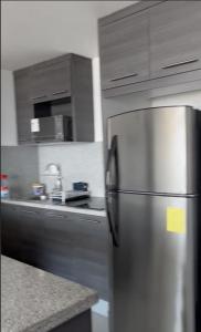 een keuken met een roestvrijstalen koelkast en kasten bij Lujosa Suite; confort, seguridad in Guayaquil