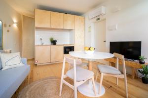 cocina y sala de estar con mesa y sillas en Casa da Encomenda @ Casas do Pátio (6), en Coímbra