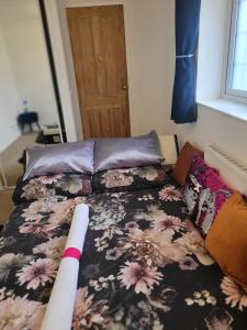 a bedroom with a bed with a flowery comforter at Chocolates&Flowers in Leverstock Green