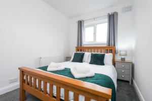 a bedroom with a wooden bed with two pillows at Rio's Retreat in Cottingham