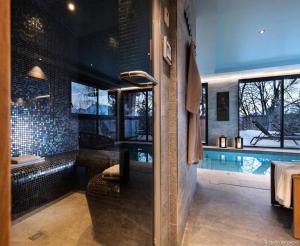 a bathroom with a tub and a swimming pool at Résidence Arc - Chalets 114 in Arc 1800